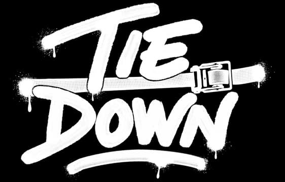Tie Down: Bold brushstroke lettering with paint splatter, strap-buckle accent, underline.