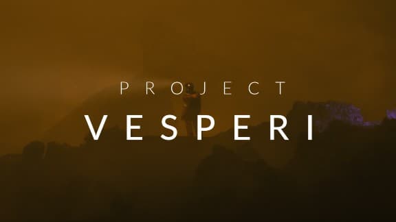 Project Vesperi: Lone figure in foggy, dark rocky landscape with soft yellow light. Sci-fi setting with eerie ambiance.