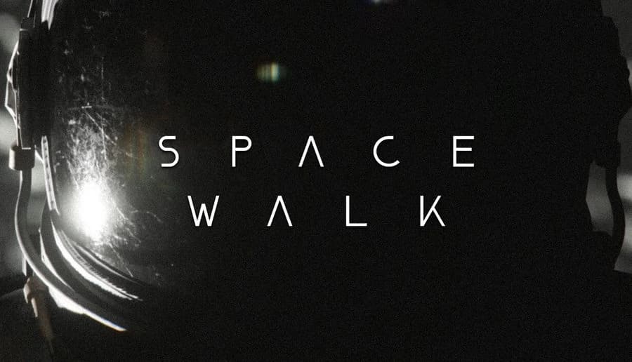 SPACE WALK: Close-up of astronaut helmet visor with bright glare and scratches, dark space backdrop around it.