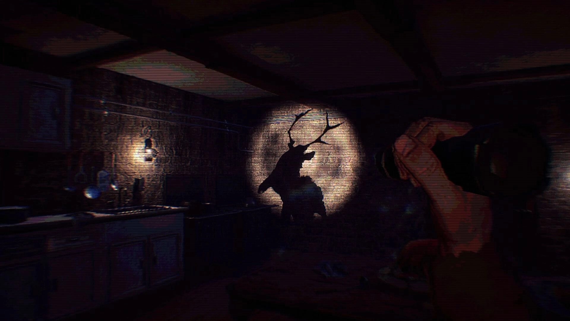 Ghost Scout: Flashlight reveals a stag-headed shadow on a wall in a dim cabin room with desk and lamp.