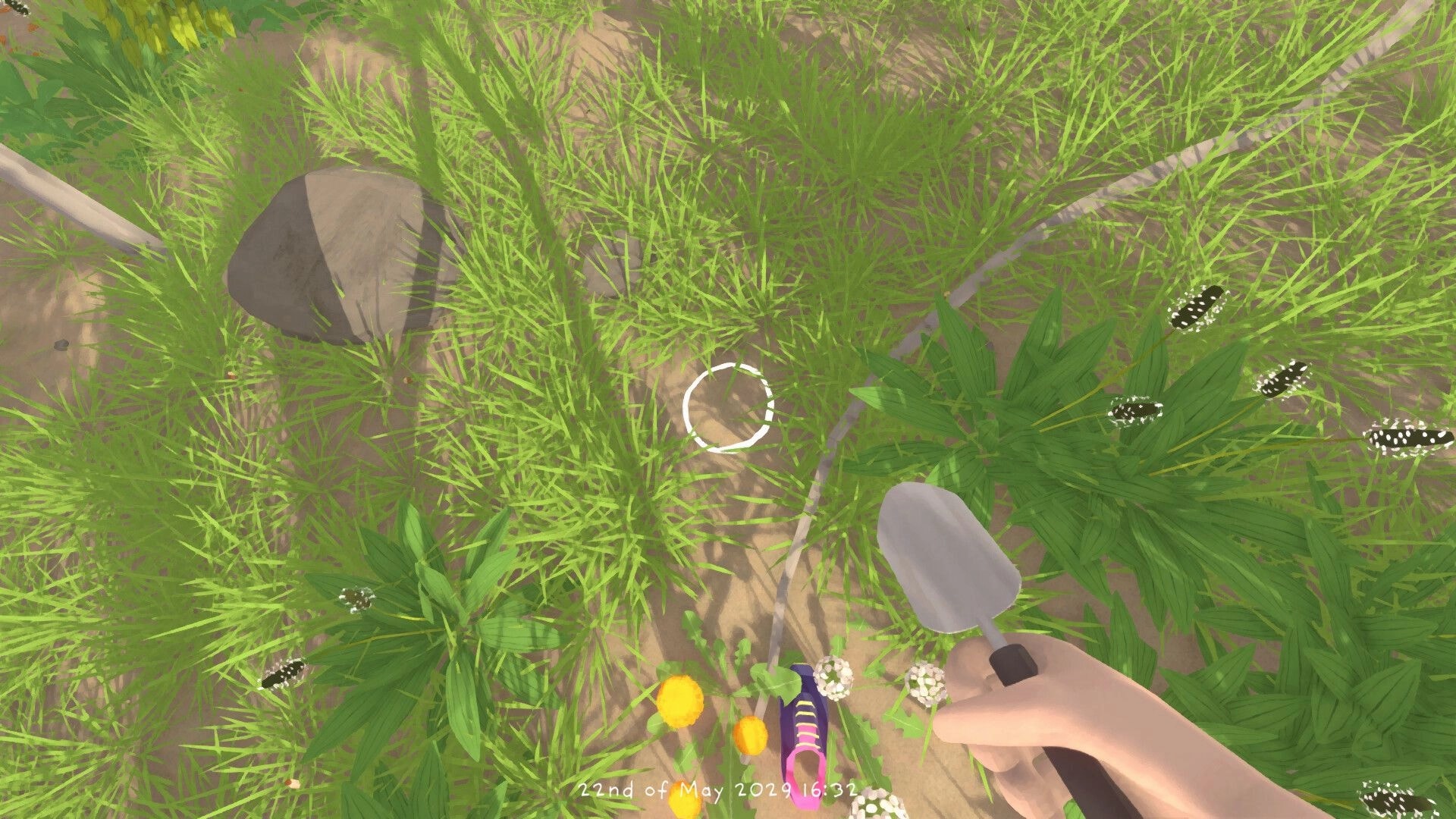 Grow Wild: First-person trowel tool over grass and wildflowers, aiming reticle on sandy ground patch.
