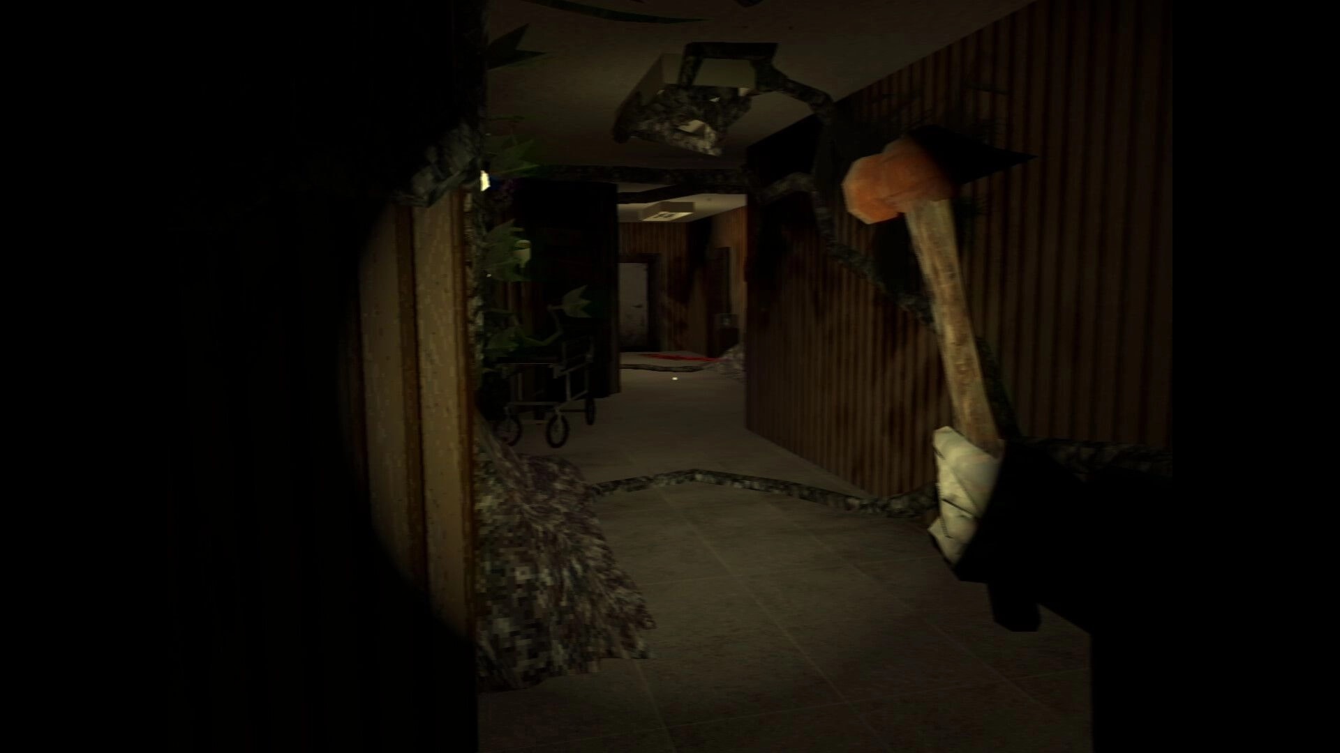 It Breathes: First-person view holding a hammer in a dark hospital corridor with debris and gurney.