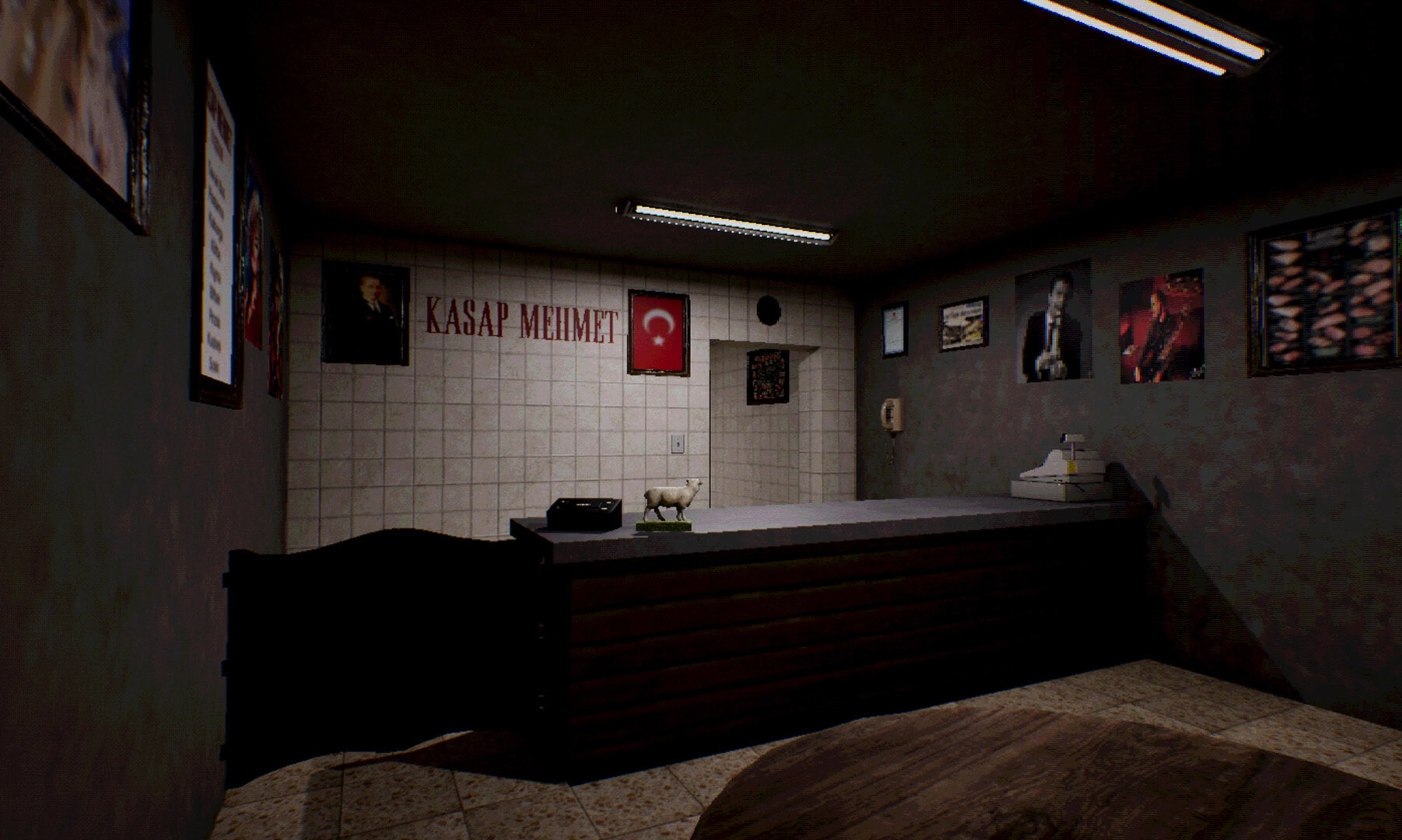 KASAP: Empty butcher shop counter with scale and cash register under fluorescent lights and wall photos.
