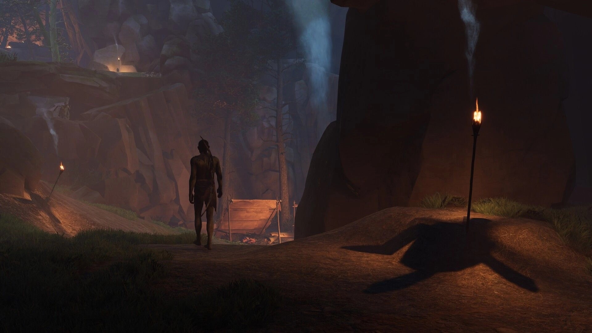 Kiipluu: Lone hunter walks toward a torchlit camp in a rocky canyon with cliffs and misty falls.