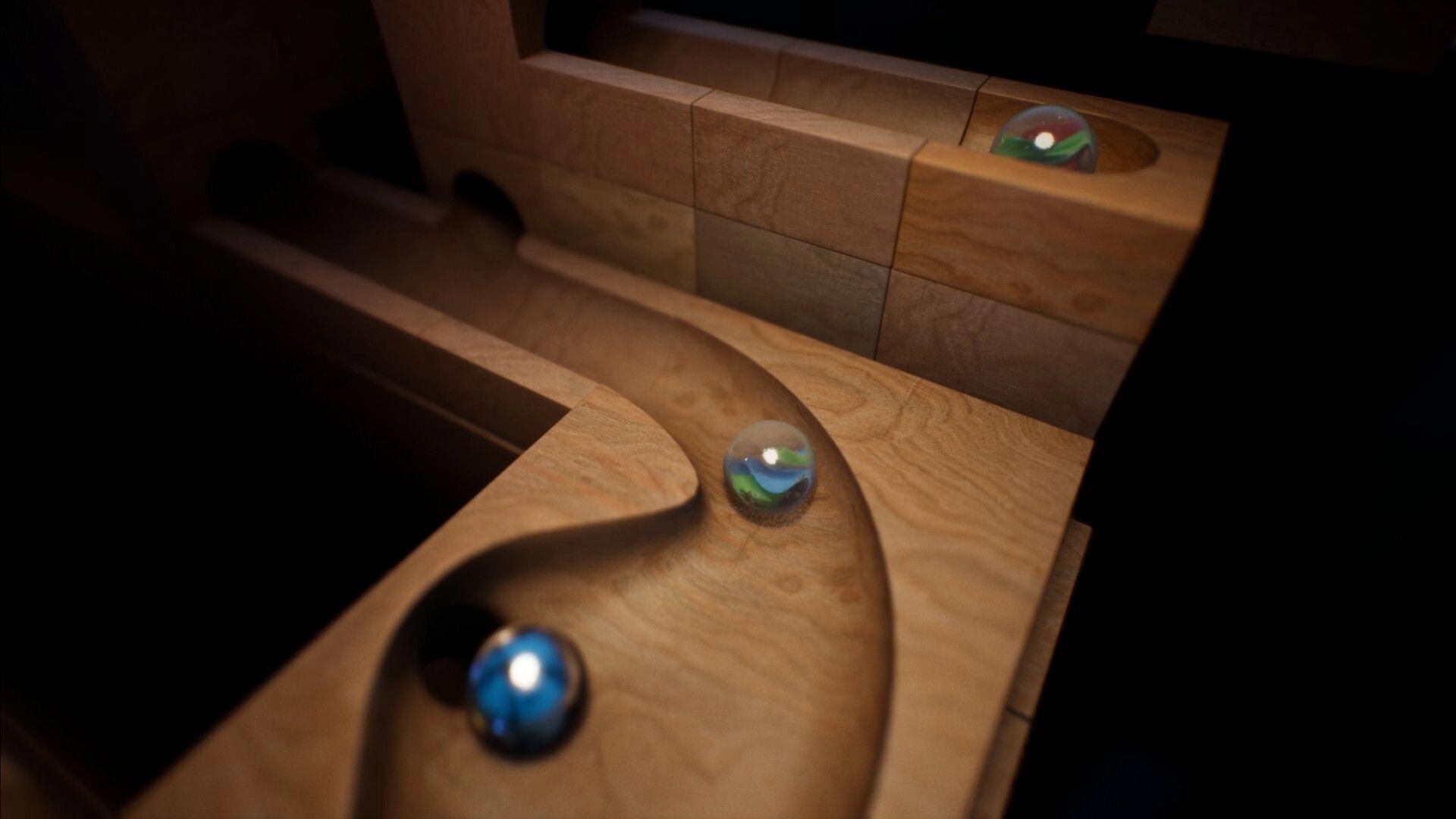Marblearium: Three glass marbles rolling along curved wooden grooves in a close-up marble run track.