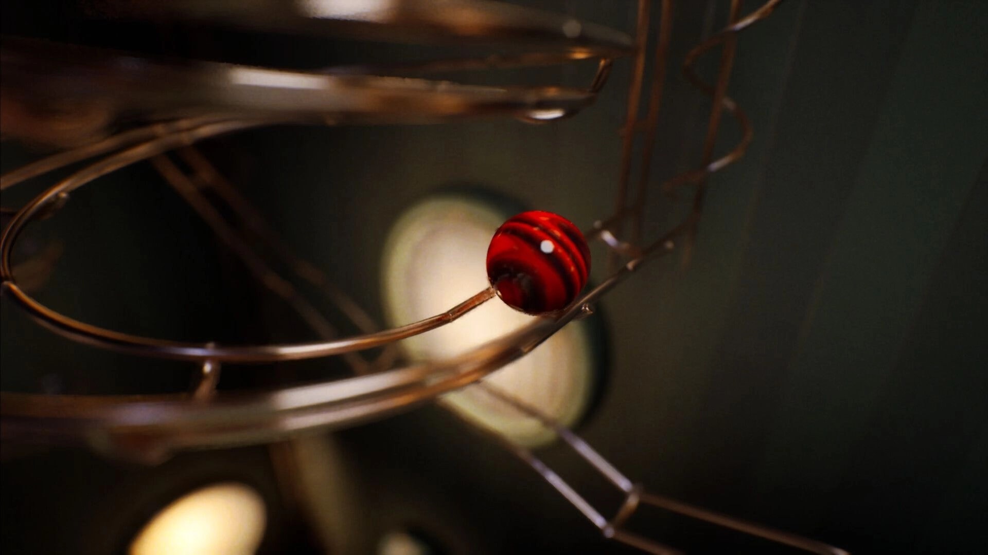 Marblearium: Red striped marble rolling along a curved metal track in a dim, blurred marble run.