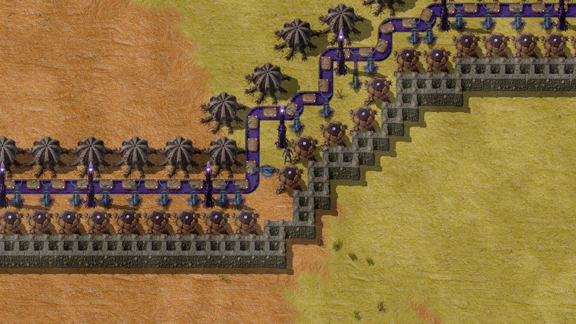 Swarmdustry: Purple conveyor line with organic turrets and walls guarding a sandy desert base path.