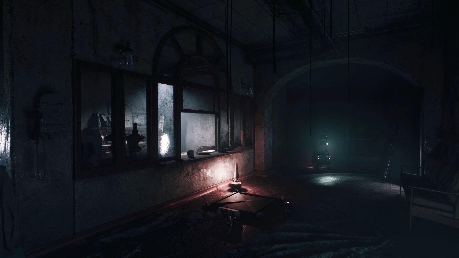 UNHOST: Remote-controlled robot with headlamp rolls down a dark hospital corridor past windows and debris.