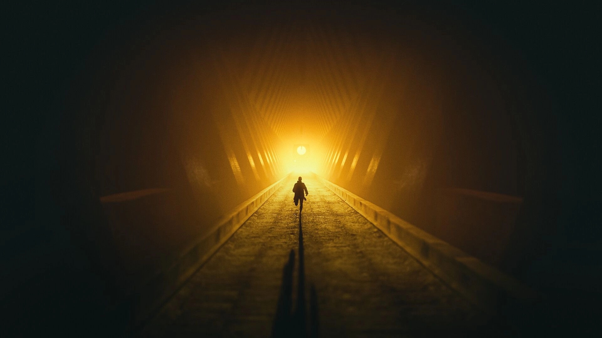 4: Lone figure runs down a tunnel walkway toward a blinding yellow light in heavy fog and shadows.