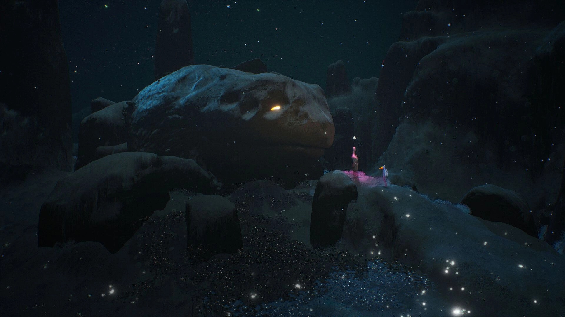 Abelina: Two figures stand by a pink glow beneath a giant stone face in a starry canyon night.
