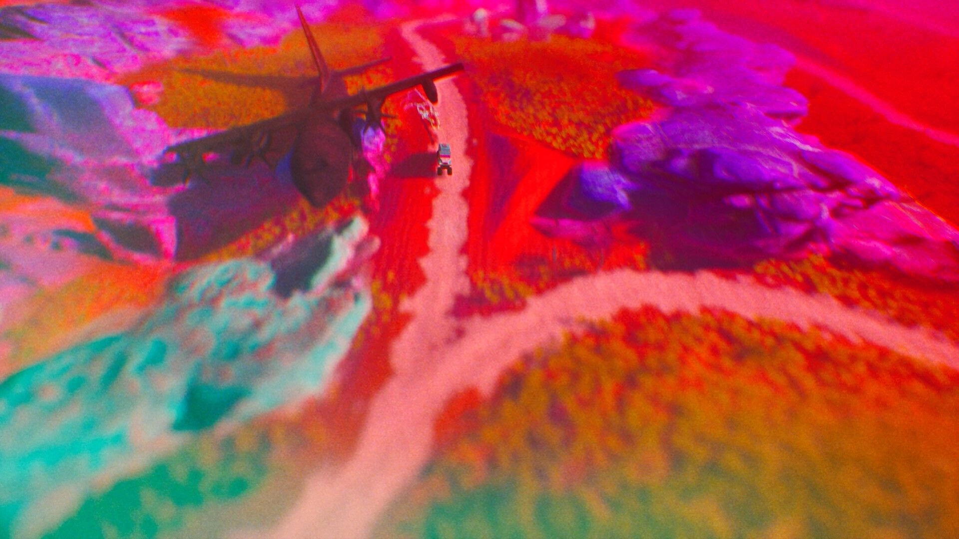ADRIFT: Aerial view of a vehicle navigating winding desert roads with vibrant, surreal landscapes