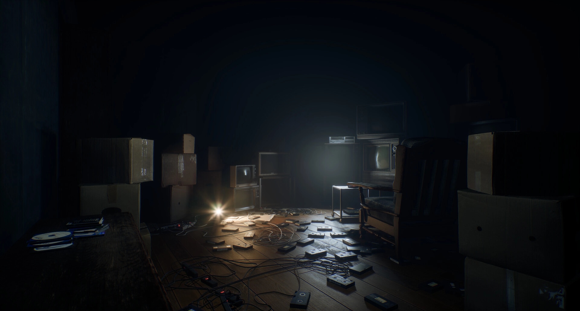 A.I.L.A: Dimly lit room with scattered VHS tapes, old TVs, and cardboard boxes creating eerie atmosphere