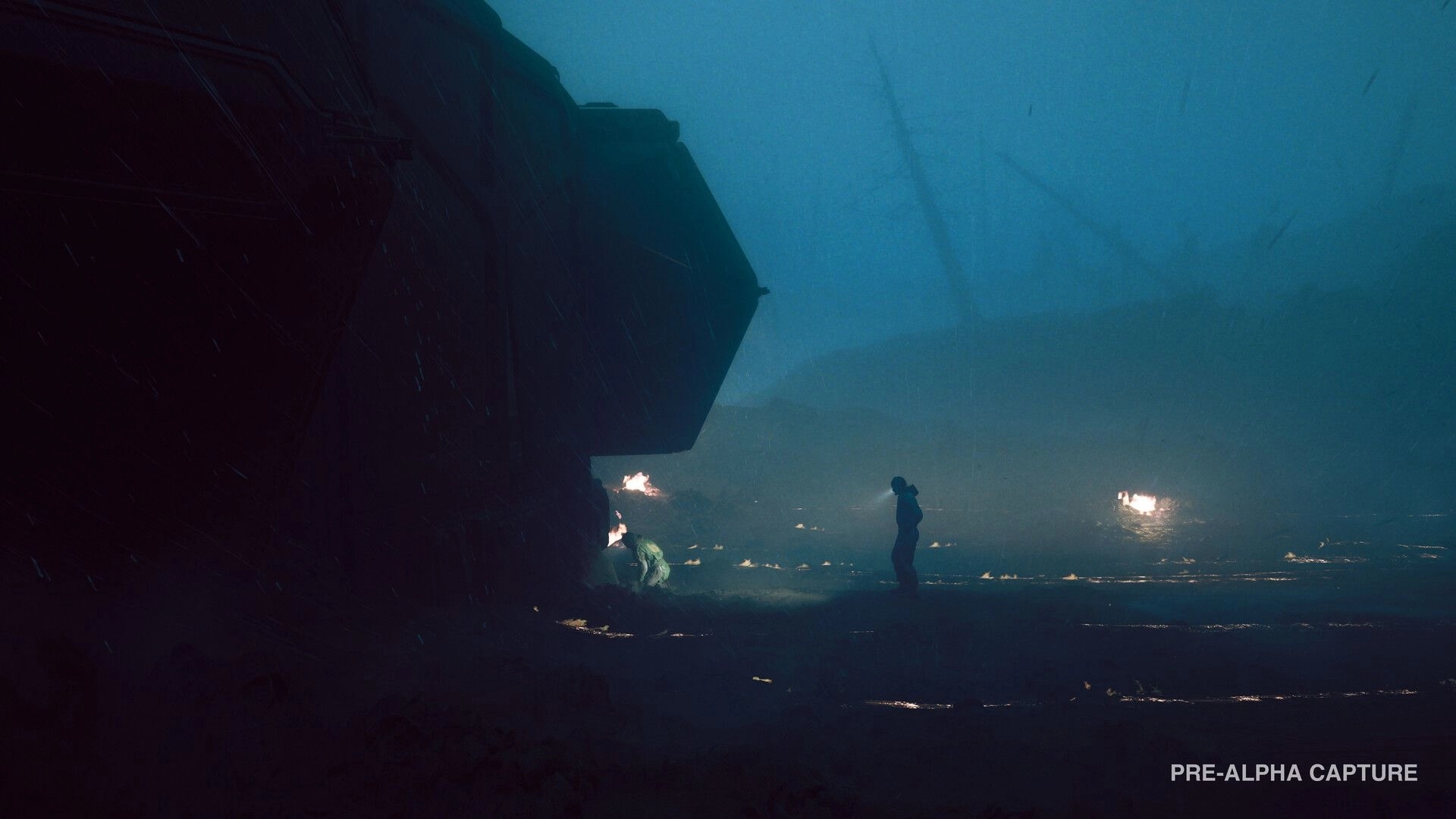 Alien: Lone figure stands near a massive wreck in rain-soaked fog with small fires burning nearby.
