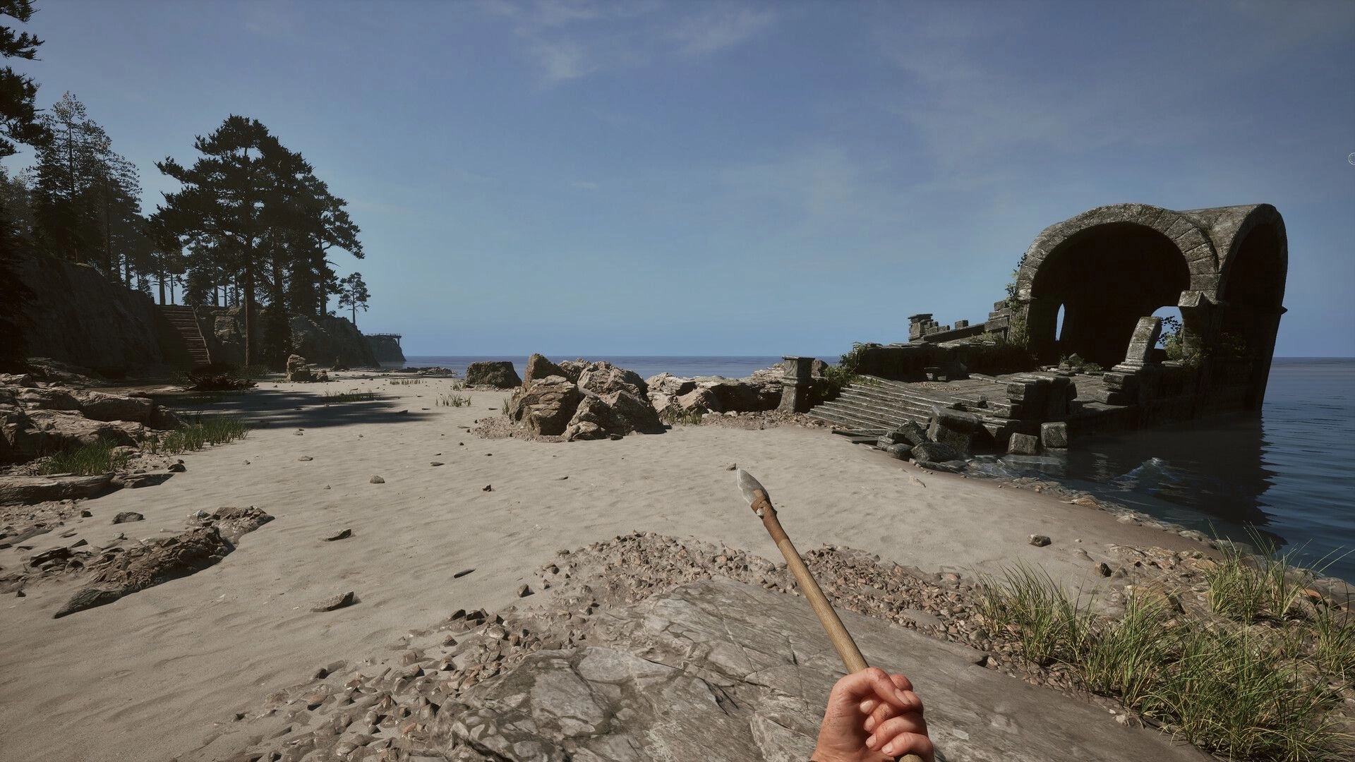Among the Trolls: Player holds a spear on a sandy beach with ancient ruins and dense forest nearby