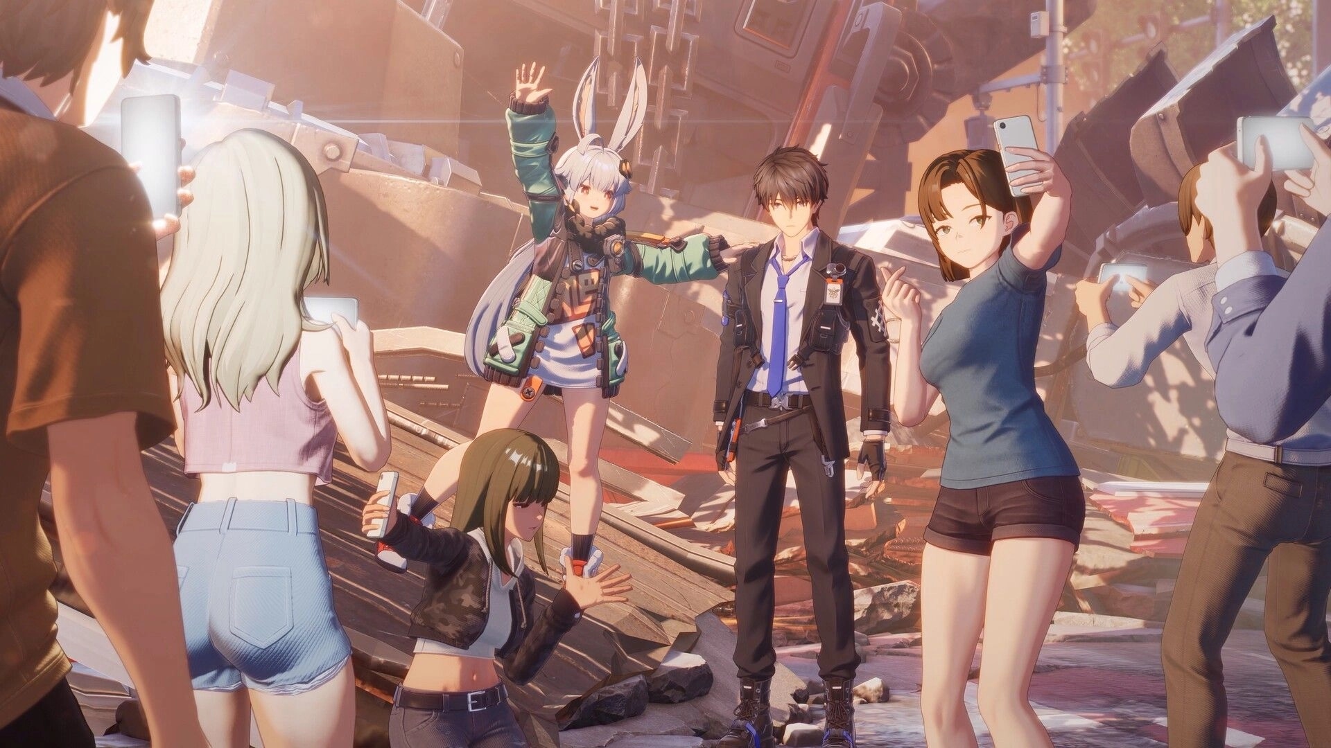 ANANTA: Bunny-eared girl poses by a stoic man as bystanders film amid twisted metal wreckage outdoors.