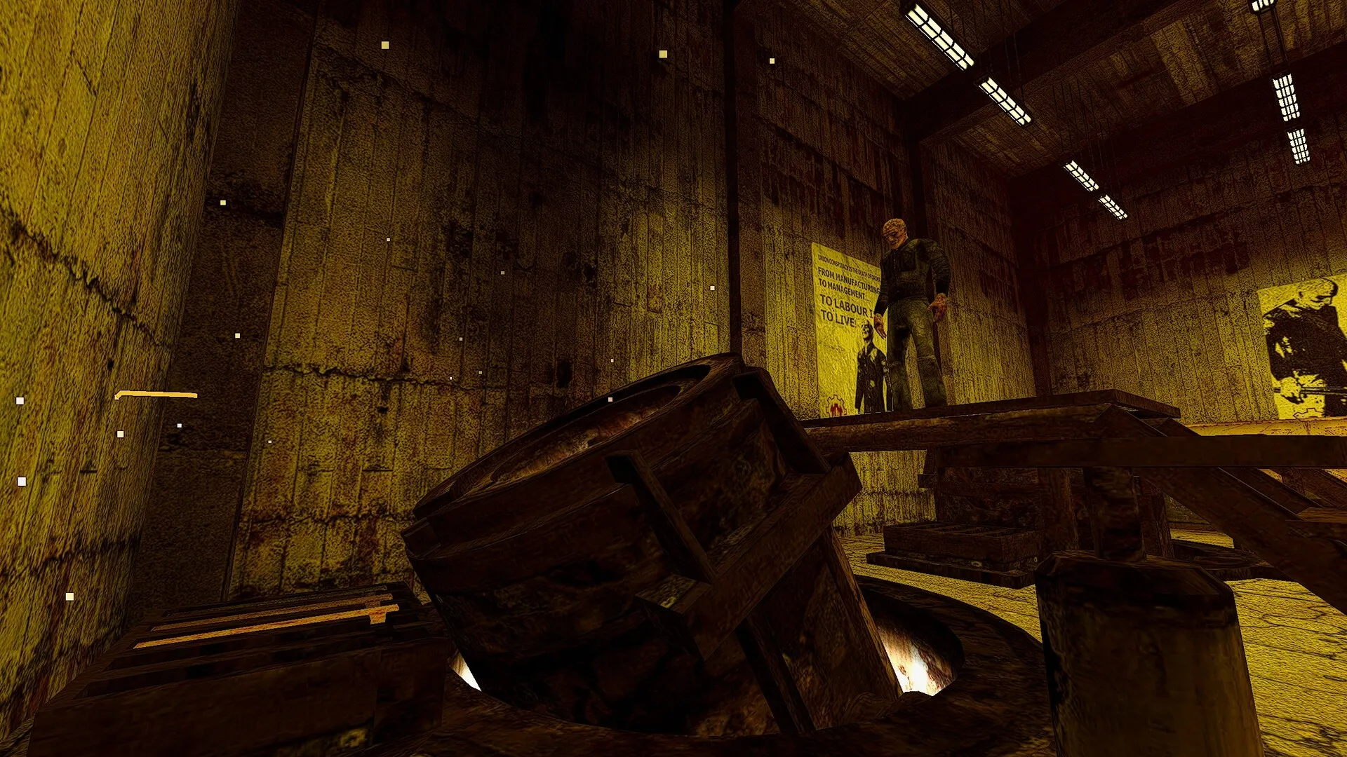 ANEURISM IV: Character stands on platform in dimly lit factory with large metal vat and industrial posters.