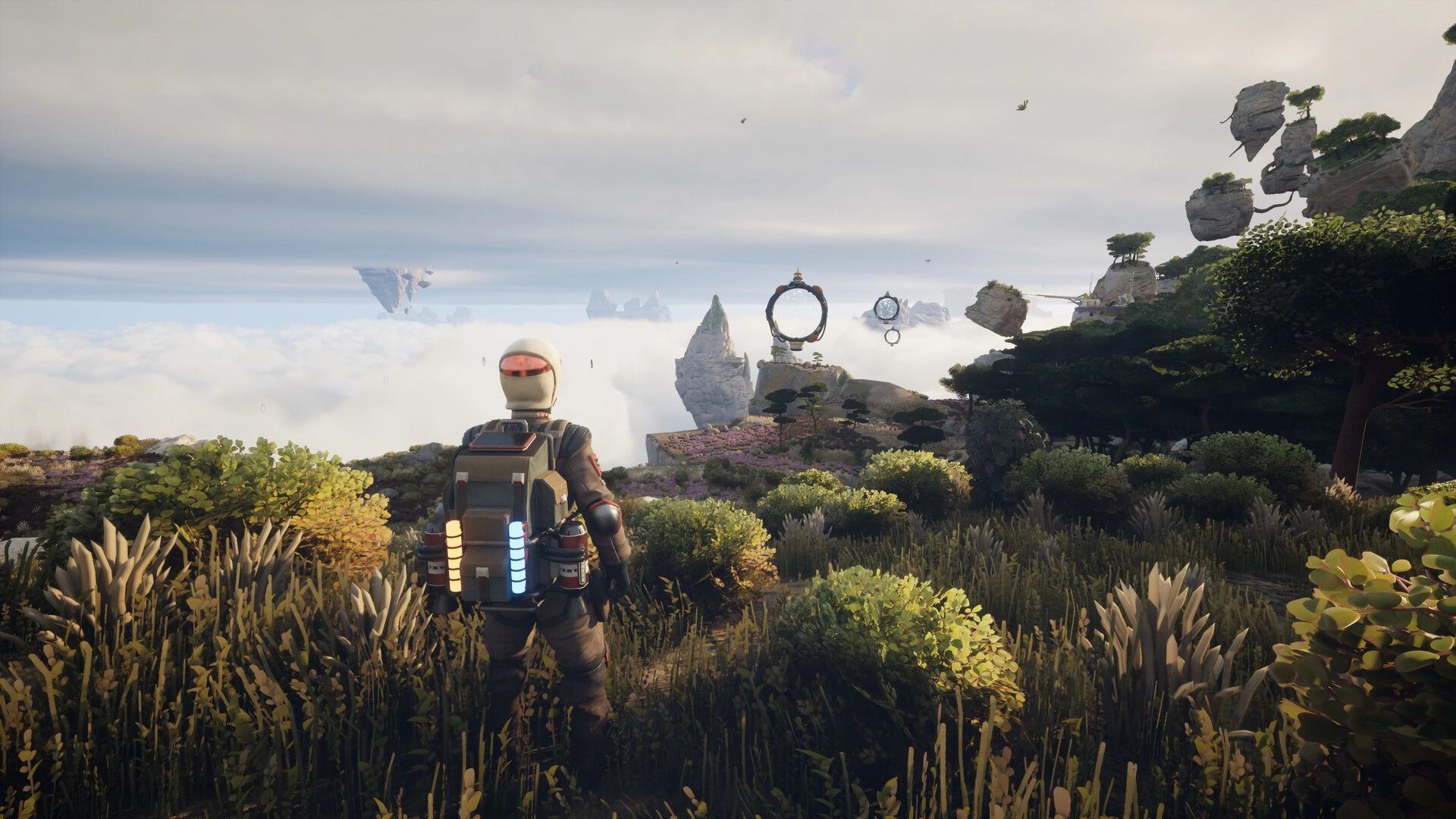 ATMOSFAR: Astronaut stands on grassy cliff facing floating ring portals and islands above clouds.