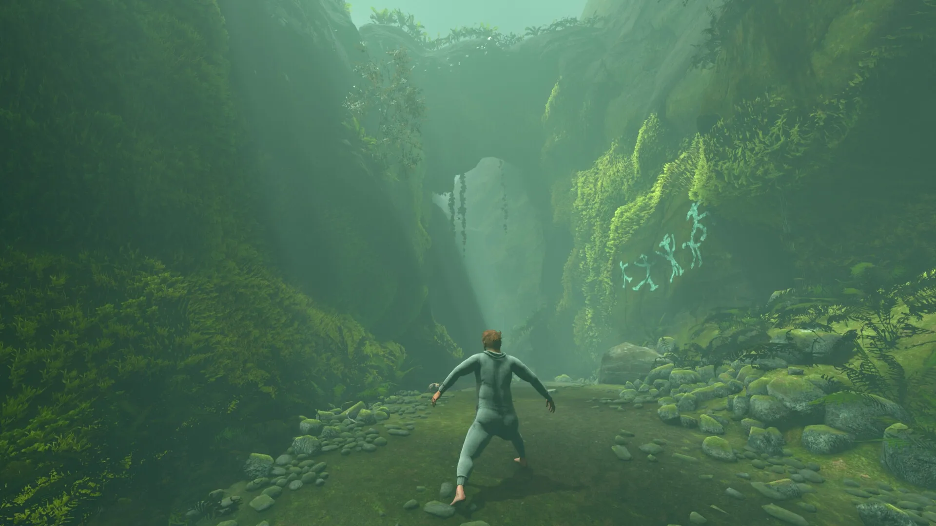 Baby Steps: Nate exploring a lush, green canyon with ancient wall drawings and scattered rocks