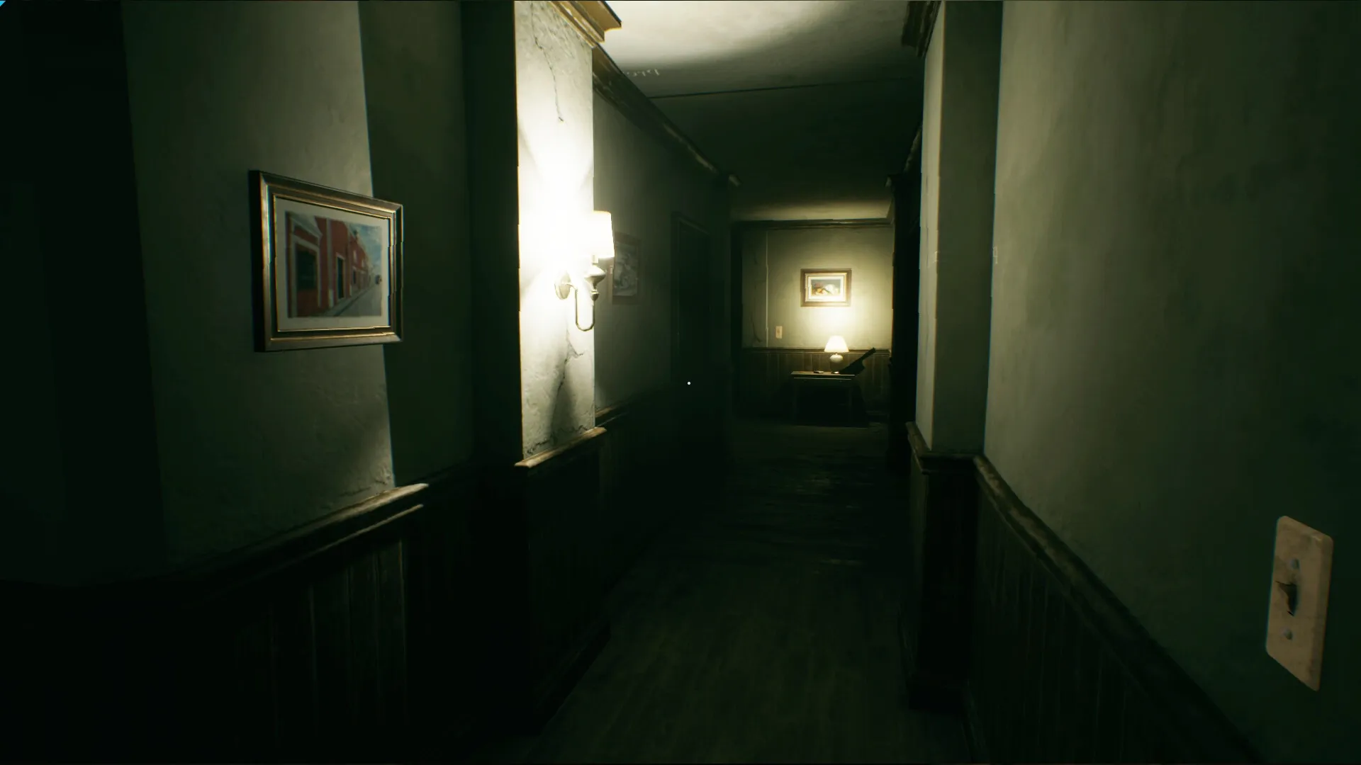 Baptiste: Dimly lit hallway with a lamp-lit table and framed pictures on the walls at Jagged Shore Cliff.