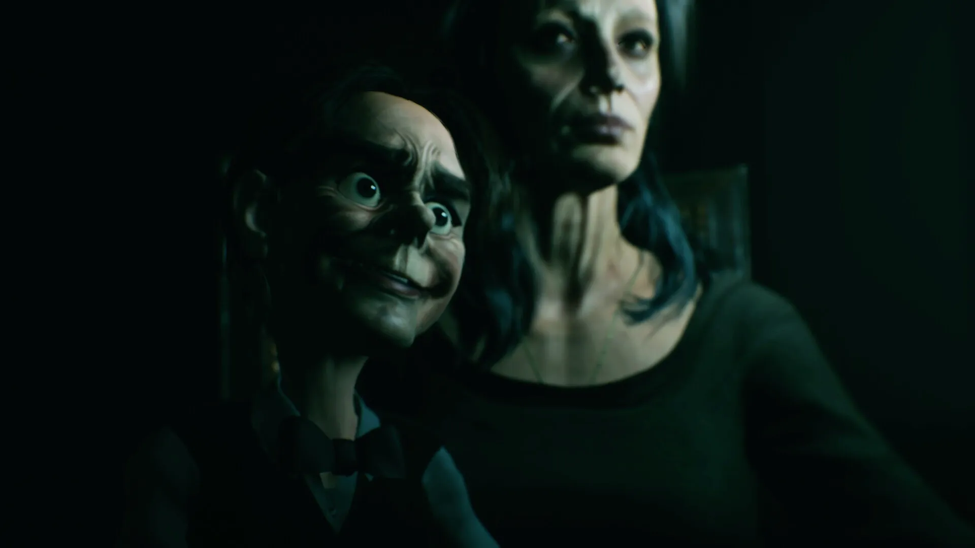 Baptiste: Eerie scene with a puppet and a woman in a dimly lit room, highlighting suspenseful ambiance.