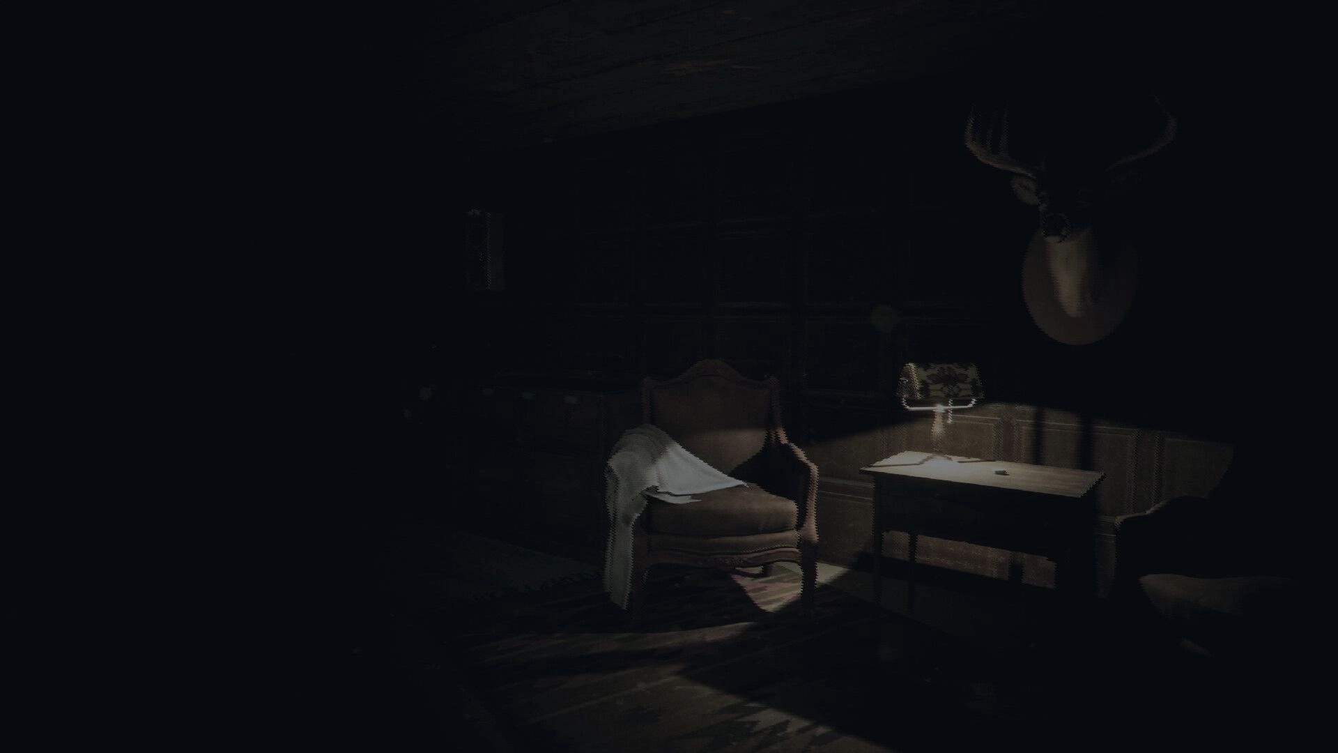 BARABIZNA: Dimly lit room with an armchair, side table, and deer head mounted on the wall.