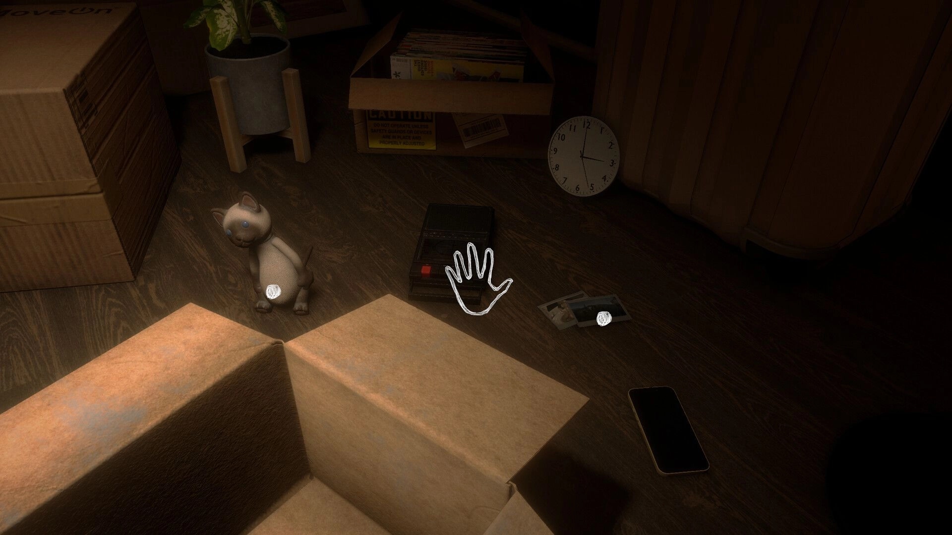 Before Closure: Hand cursor over cassette recorder near cat figurine in dim room with boxes and photos.