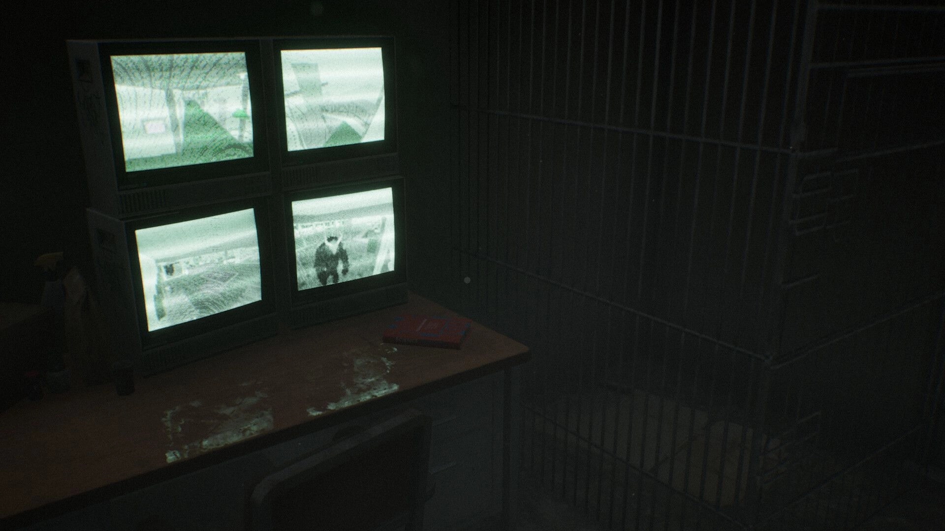 Berghotel Heist: Four CCTV monitors display eerie scenes in a dimly lit security room with a metal cage.