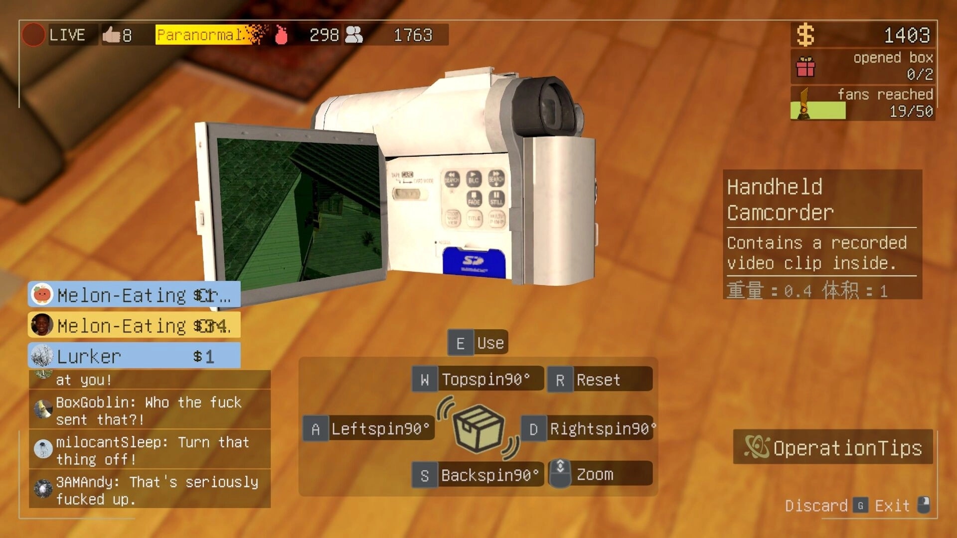 bet you won’t: inspecting a handheld camcorder item with live chat overlay in a wooden-floor room.