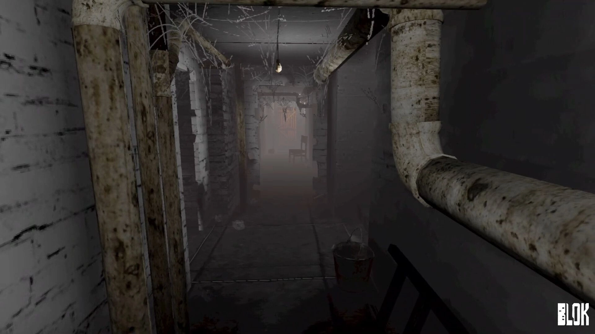 BLOK: First-person view down a foggy basement corridor with rusty pipes, bare bulb, chair ahead.