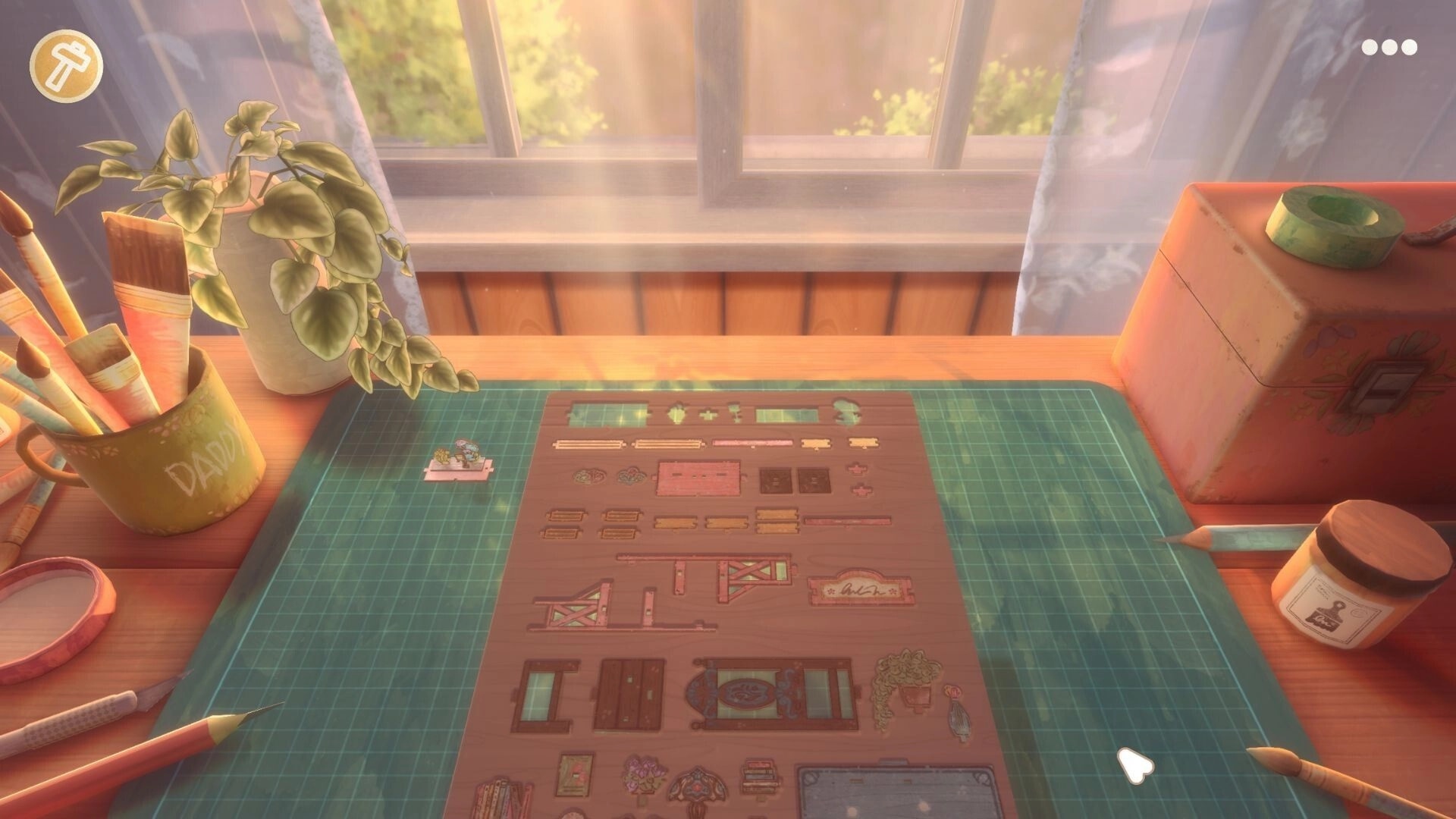 Book Nook: Crafting table view with die-cut pieces on mat, tools and window light in cozy room.