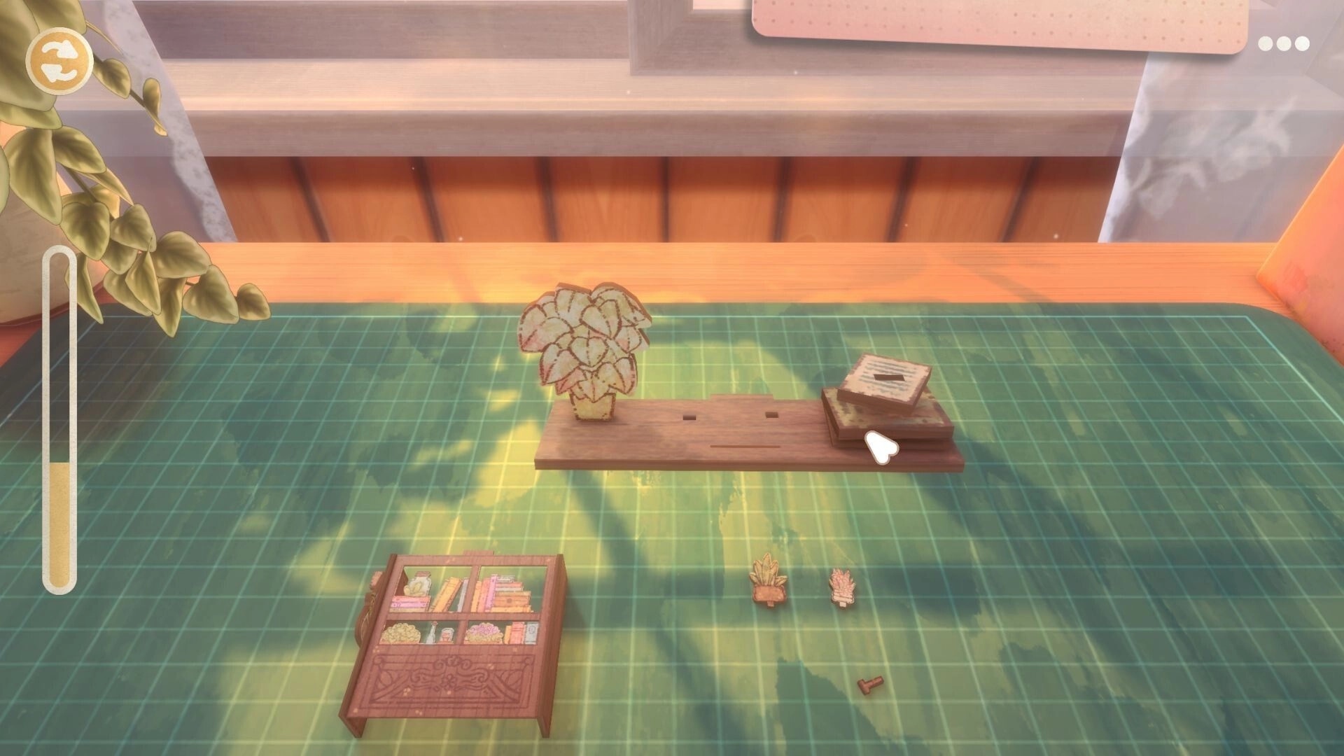 Book Nook: Placing miniature plant and books onto a wooden base on a green cutting mat workbench UI.