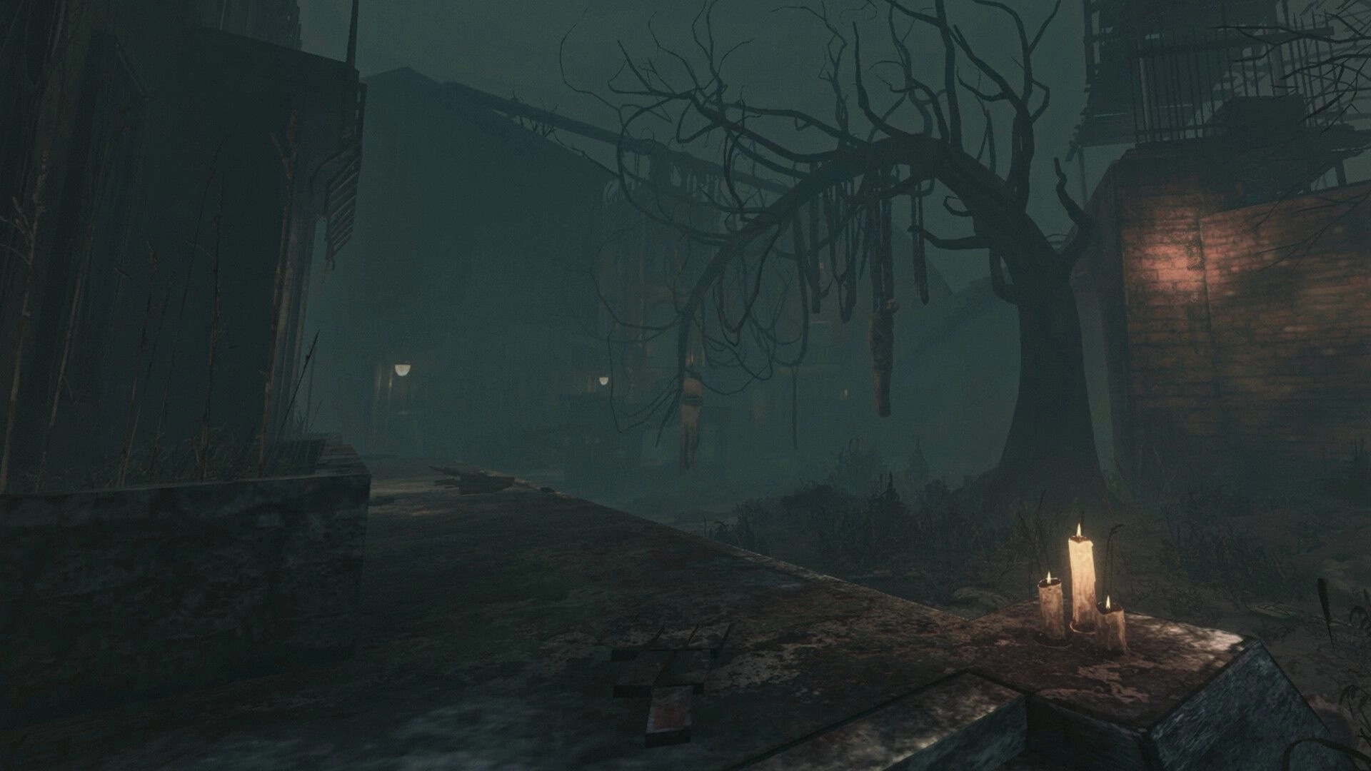 BRAMBLEFORT: Foggy street with hanging bodies in dead tree, candles on curb beside boarded houses.