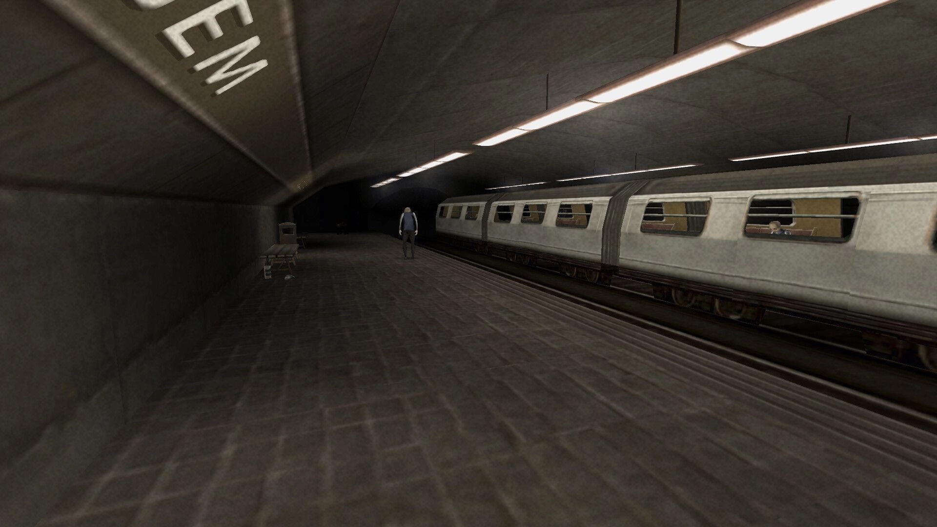 Brno Transit: Lone figure walks along dimly lit subway platform beside stationary empty train