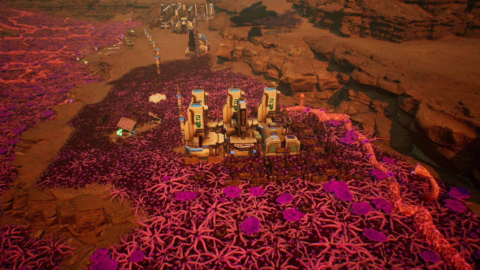 Calyx: Base buildings surrounded by alien terrain with pink and purple vegetation in a canyon setting.