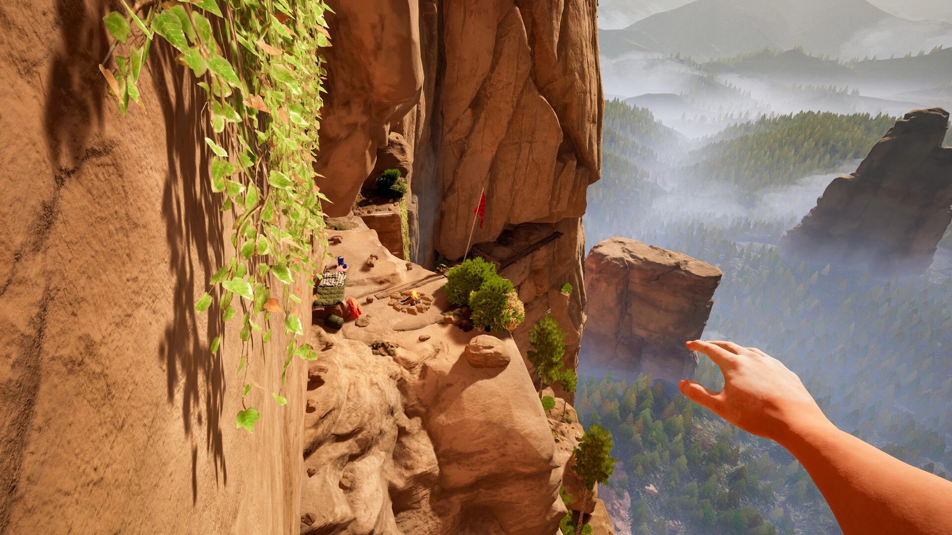 CLIMB IT!: Player's hand reaching out on cliffside camp, overlooking misty forest and distant mountains.
