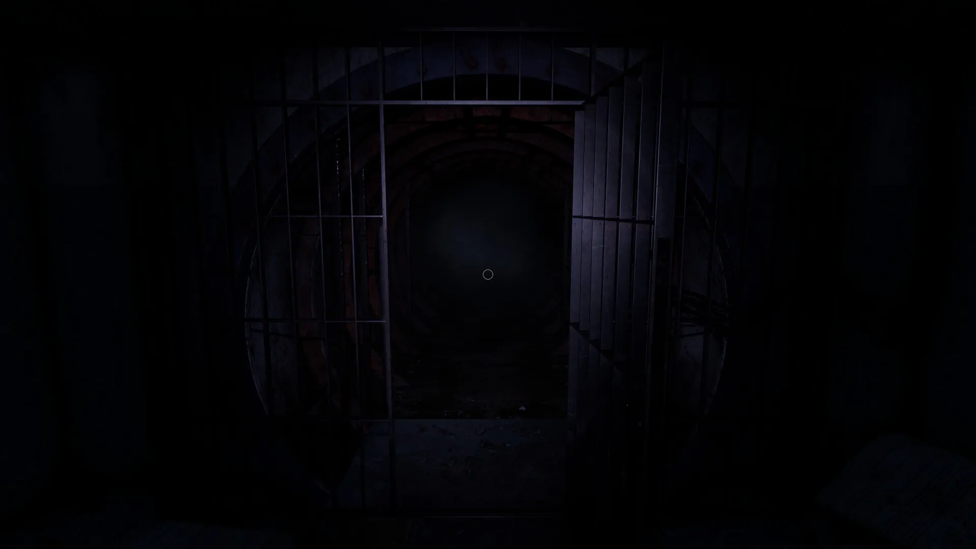 CONFINED: Dimly lit corridor with open metal gate in an abandoned bunker, darkness ahead