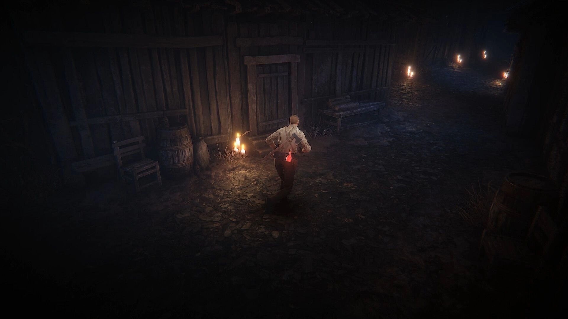 Cult Of Blood: Character cautiously exploring dimly lit village path with candles lighting the way