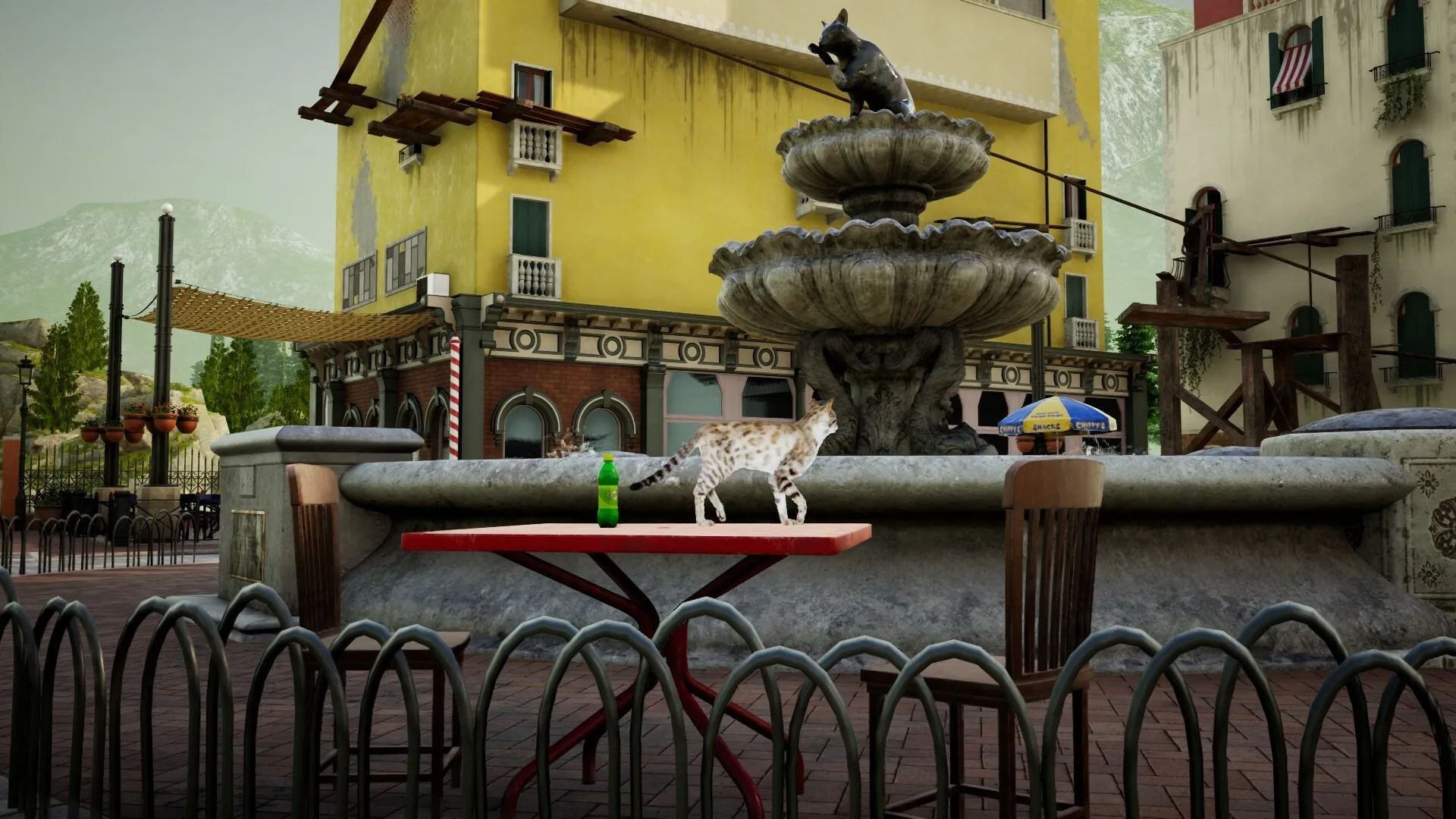 Curiosity: Cat balances on red table near ornate fountain in a sunny village square with yellow buildings.