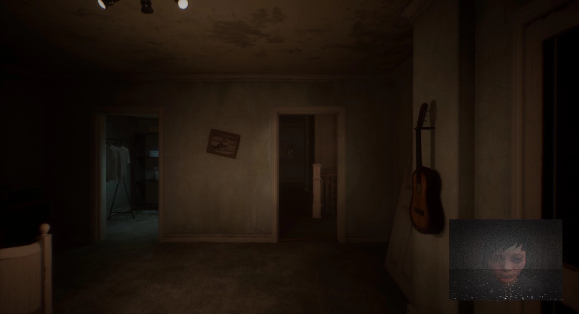 Deadcam: Dimly lit hallway with guitar on wall; Margo's eerie face visible on headcam footage