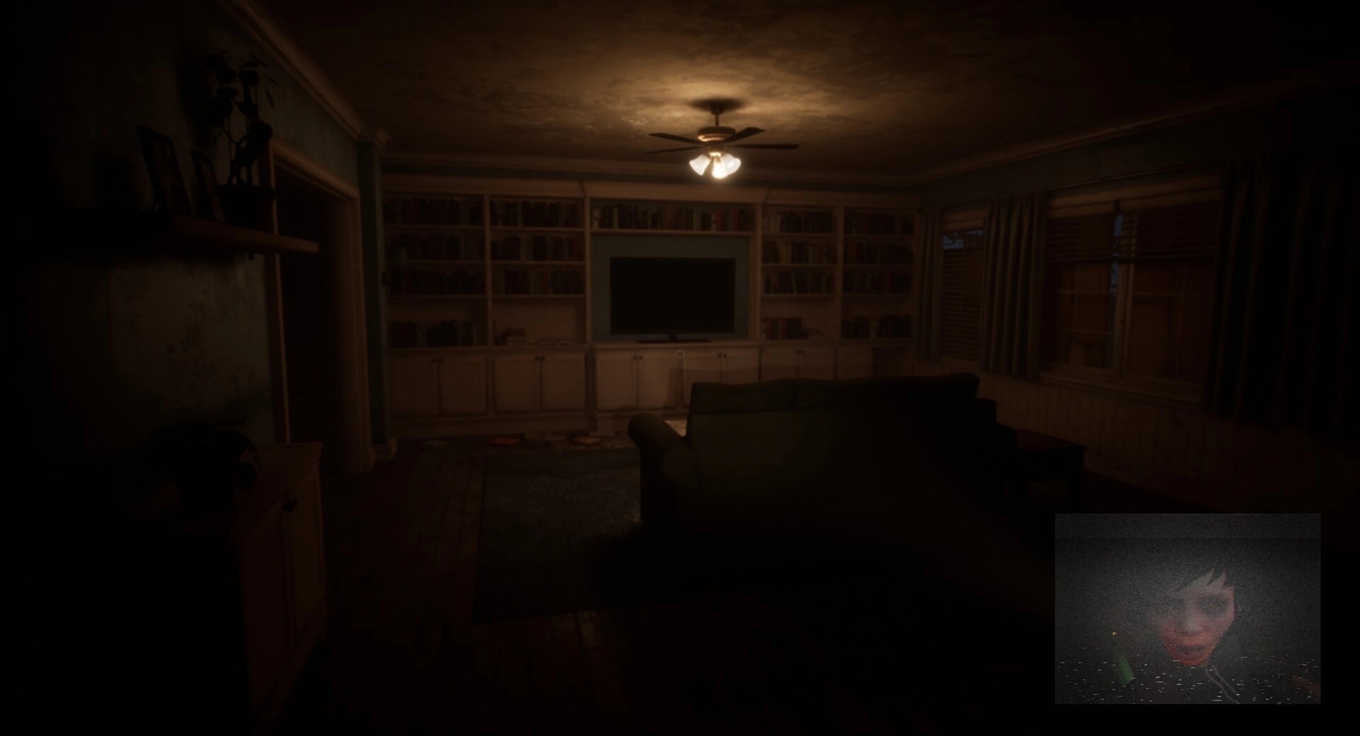 Deadcam: Dimly lit living room with TV, couch, and eerie live headcam feed of Margo in lower corner