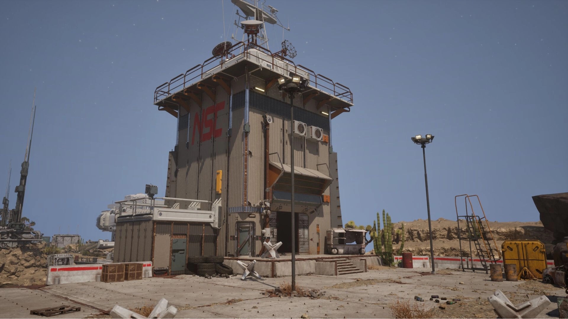 Desserted: Abandoned desert facility with tall building, scattered debris, and distant rocky terrain
