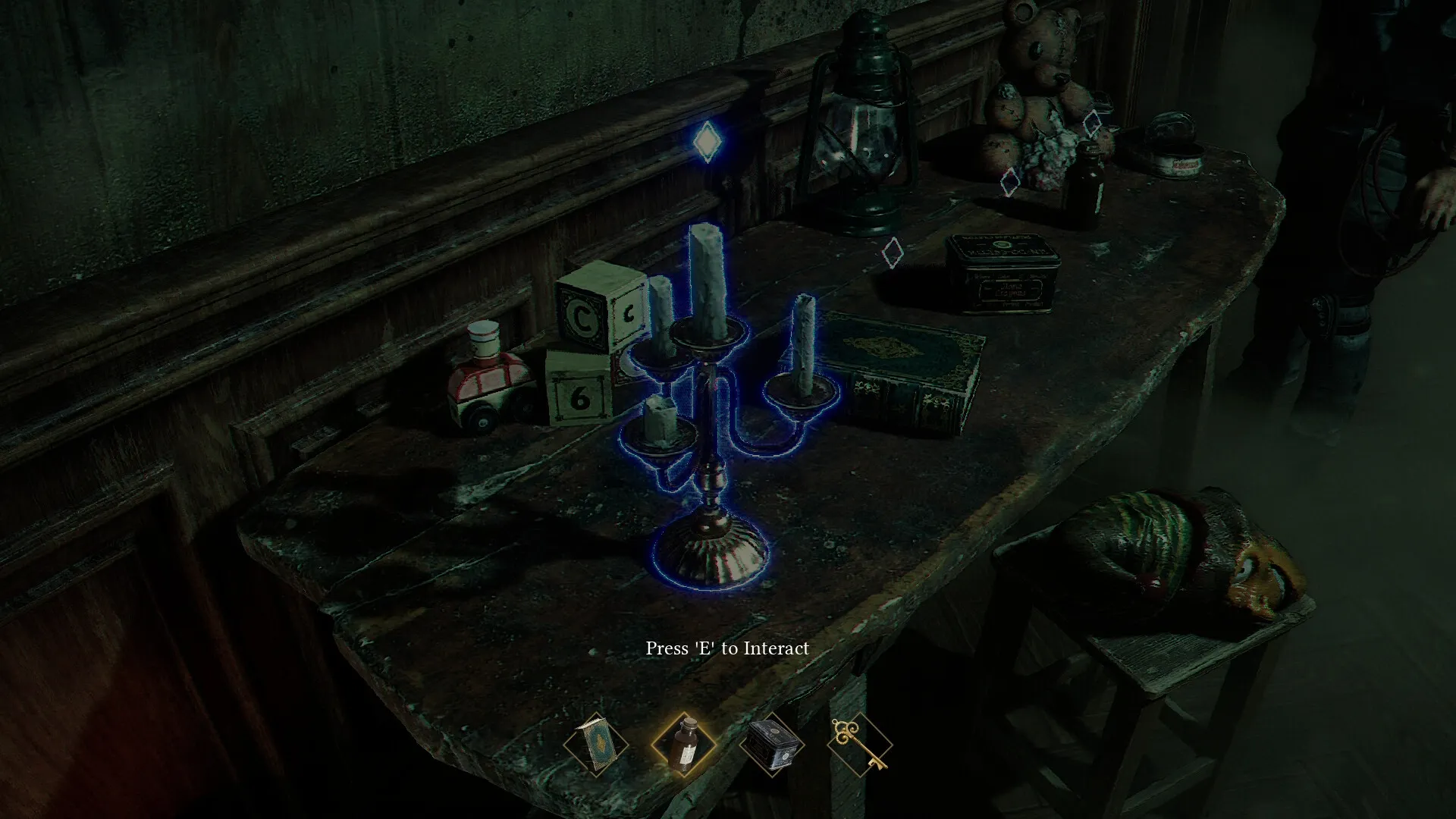 Dream Eaters.exe: Player examines a candle-lit table with toys and books in a dimly lit room.