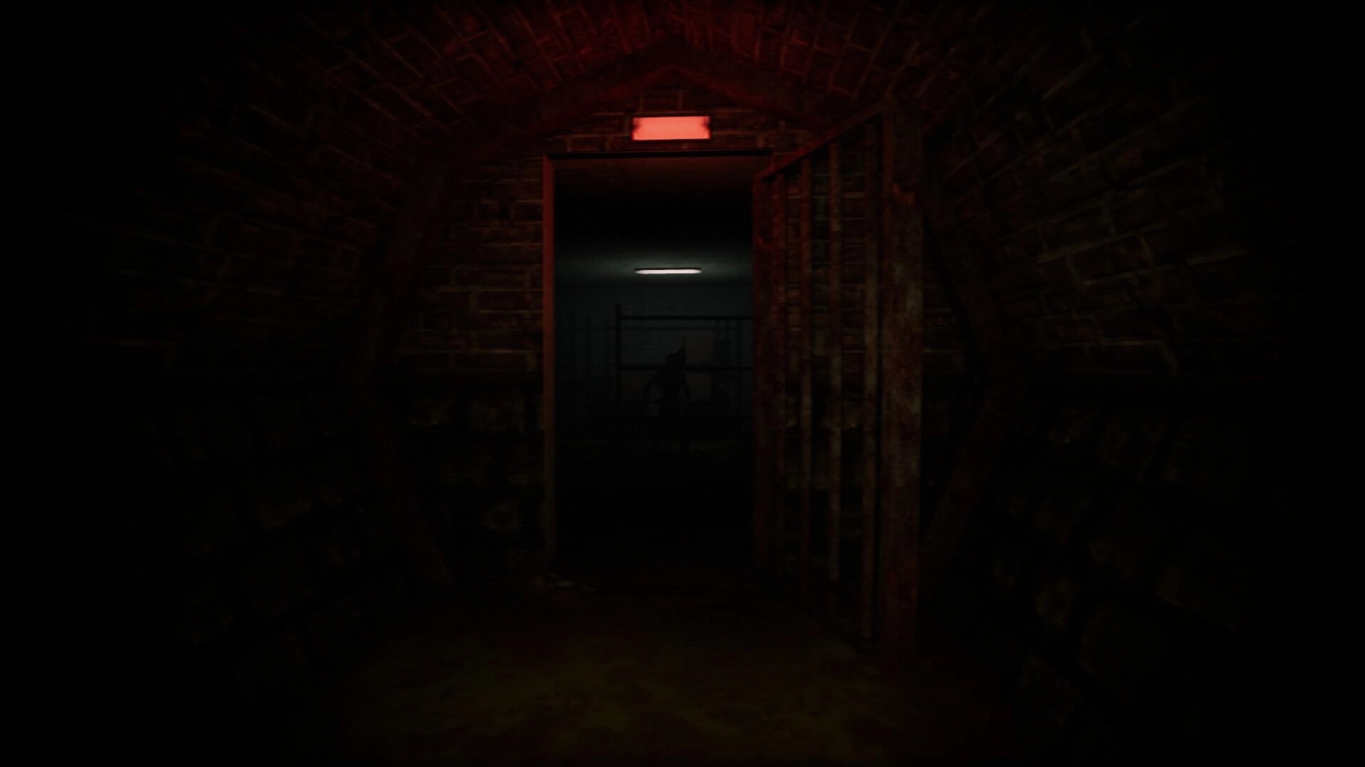 Dweller: Shadowy figure at doorway in dimly lit sewer tunnel with red emergency light overhead