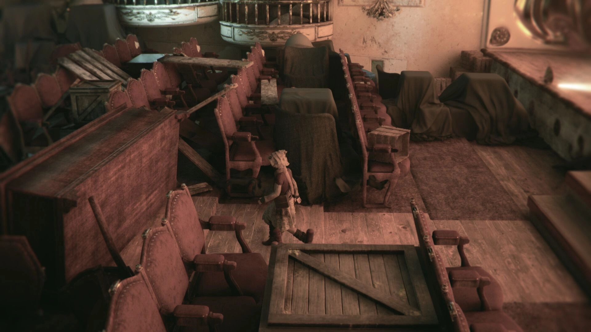 EONA: Small character sneaks between piled theater seats and covered furniture in dusty balcony hall.