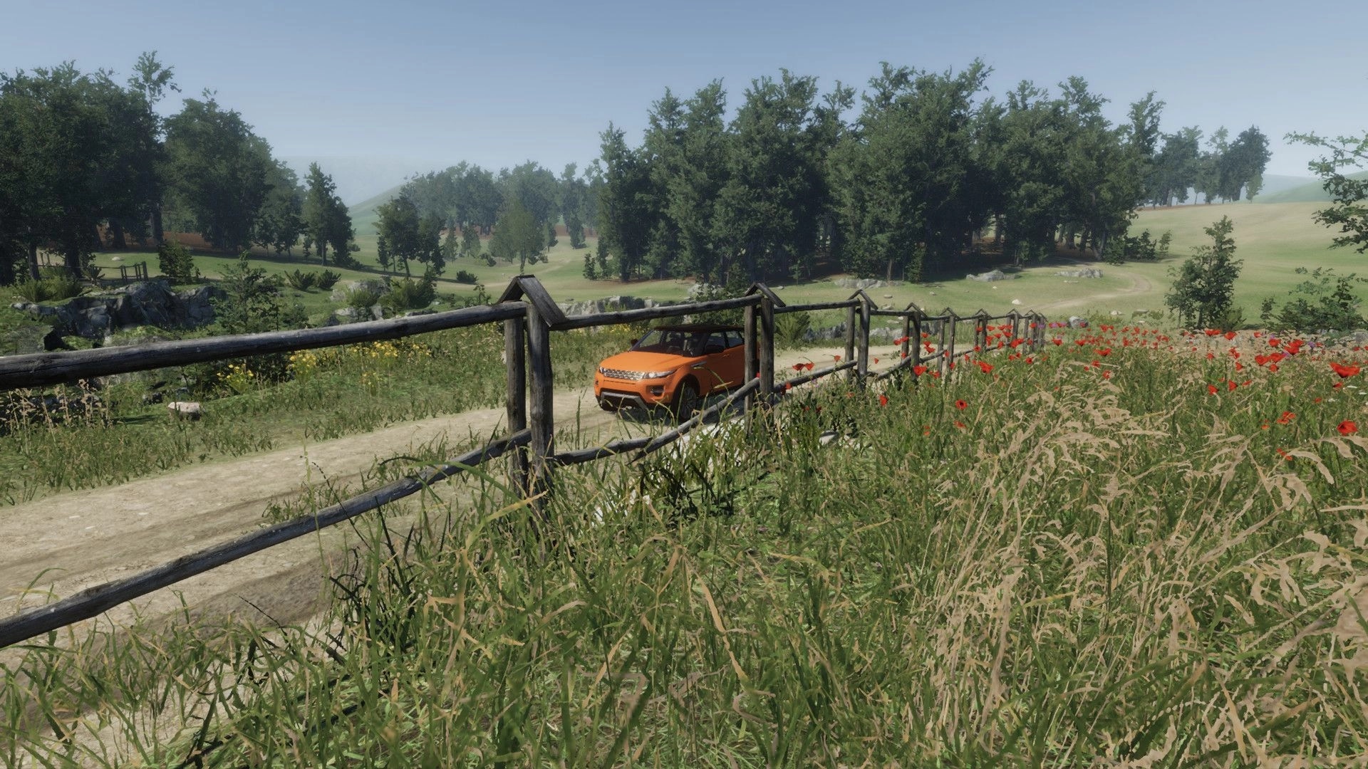 eXpanSIM: Orange SUV driving on dirt path through lush green countryside with trees and wildflowers