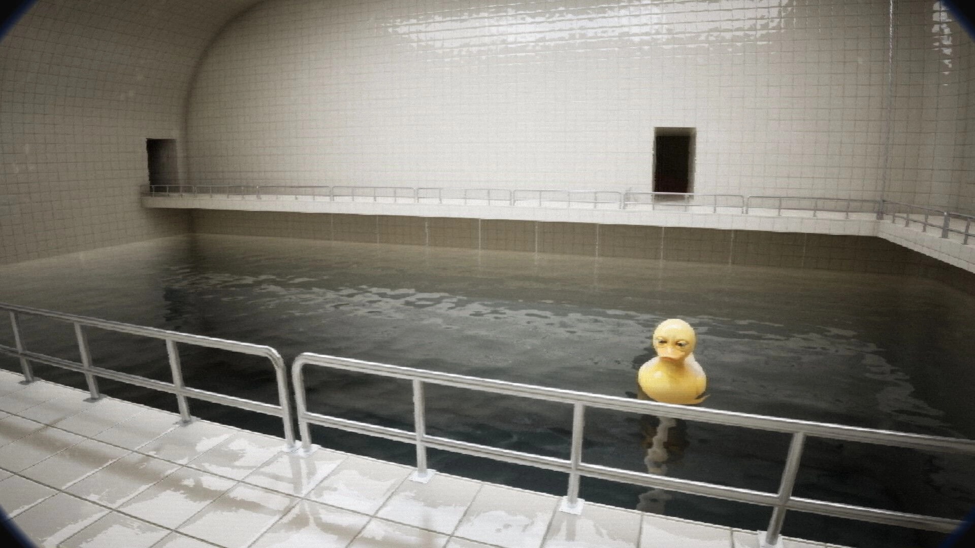 FailRooms: Player views a yellow rubber duck floating in a tiled indoor pool with metal railings.
