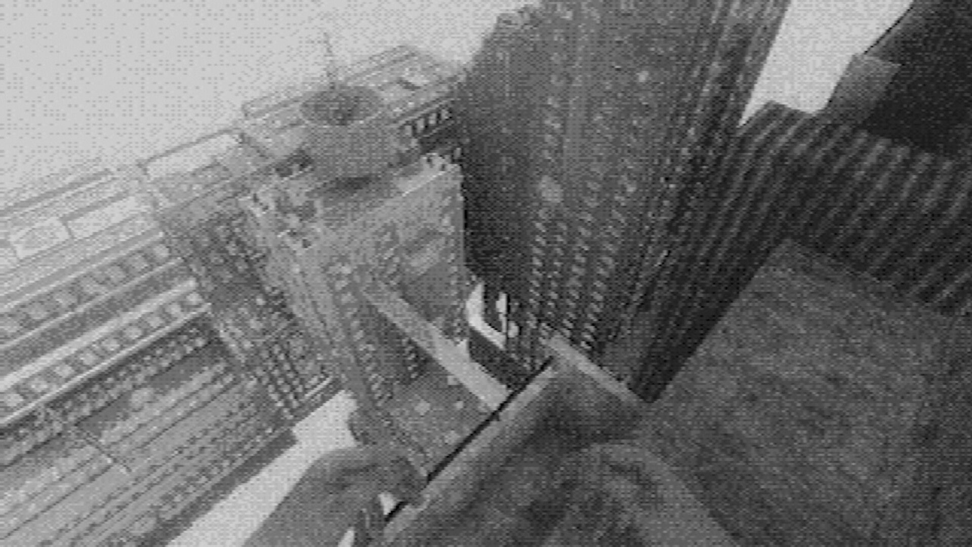 Fallgrade: First-person view from a rooftop ledge overlooking blocky high-rise buildings in haze.