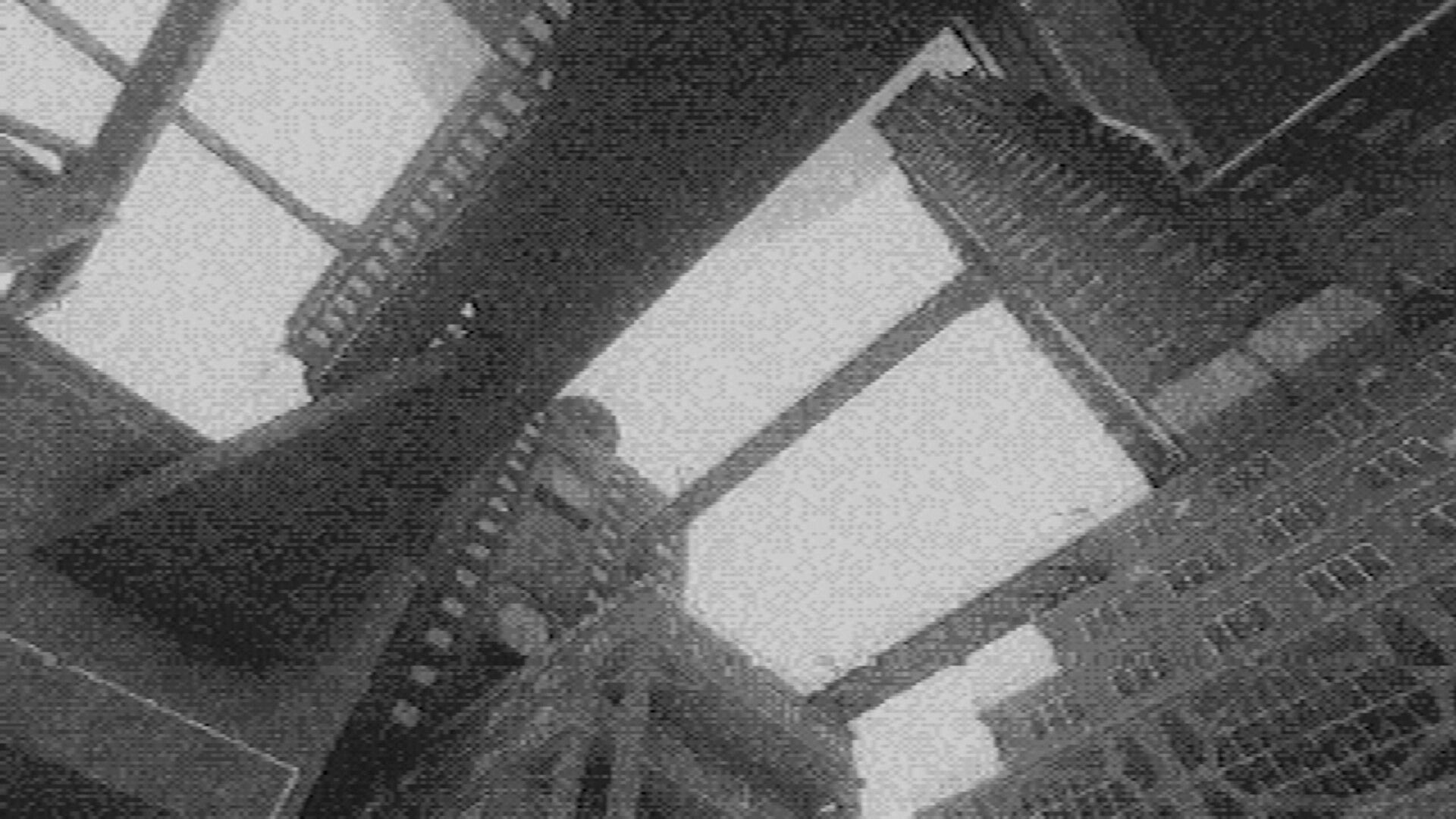 Fallgrade: Tilted view up at brutalist concrete towers and skybridges in grainy monochrome haze.