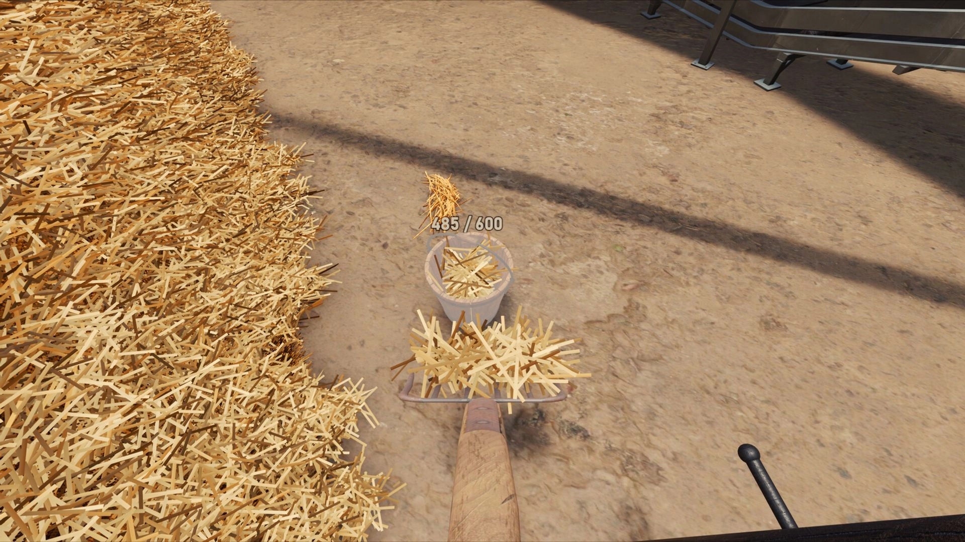 Find The Needle: Scooping hay into a bucket with 485/600 counter beside a giant haystack yard.