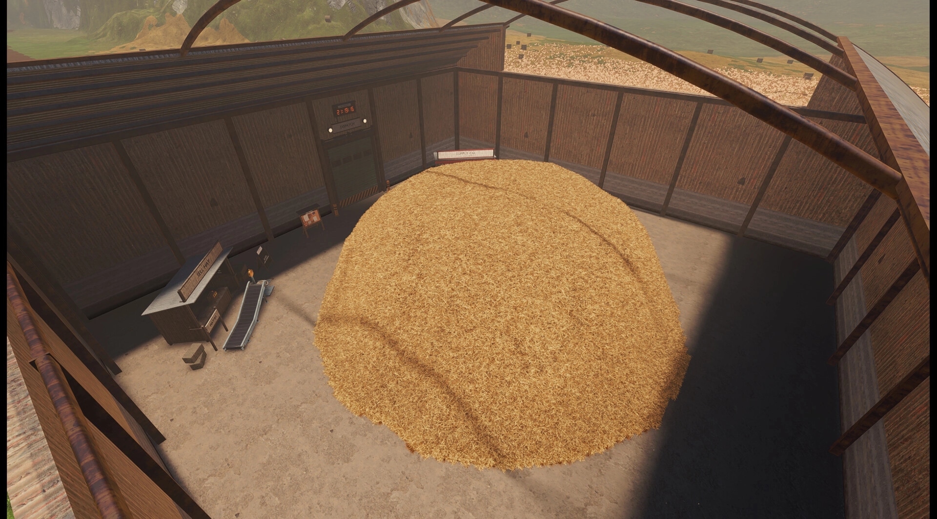 Find The Needle: Giant hay pile beside sell station and conveyor inside a walled haybarn arena.